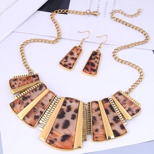 Détail d'un ensemble de bijoux léopard vintage avec collier et boucles d'oreilles sur blanc
