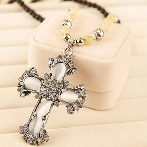 Detail of vintage cross pendant with cat eye stones and crystal on beaded sweater chain