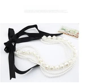 Détail d'un collier de perles multicouches avec rubans de soie noirs et perles de tailles variées