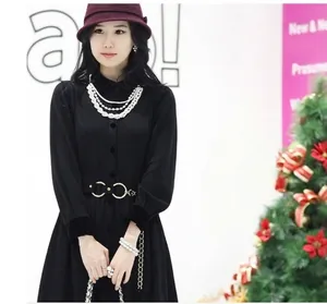 Collier de perles multicouches sur robe noire avec ceinture à boucle dorée