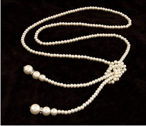 Vue détaillée du collier long en perles avec accents en strass et design de nœud élégant