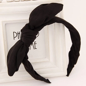 Classic black knotted fabric headband with bow detail displayed on a minimalist frame