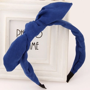 Close-up of matte dark blue fabric headband with bow bunny ear detail and protective tips
