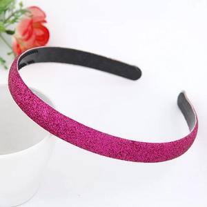 Détail d'un serre-tête rose fuchsia pailleté avec dents antidérapantes sur fond blanc
