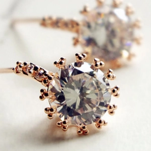 Vue détaillée de boucles d'oreilles couronne or rose avec un zircon brillant