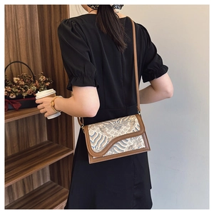 Detail of vintage retro crossbody bag with blue wave pattern and brown leather trim
