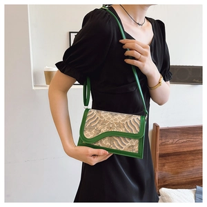 Detailed view of vintage fabric patterns and bright green leather trim on a crossbody bag