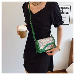 Ethnic style crossbody bag with wave jacquard pattern shown in a lifestyle street setting