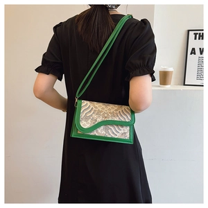 Close-up of a vintage green printed crossbody bag worn by a model in a lifestyle setting