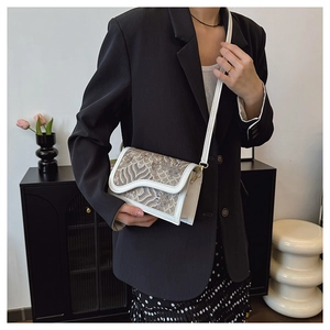 Lifestyle shot of an ethnic crossbody bag with cloud patterns on a leather flap