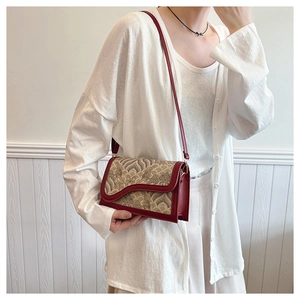 Detail of red leather crossbody bag with ethnic wave embroidery and wave-edge flap