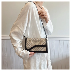 Detail of ethnic embroidery crossbody bag with traditional cloud patterns and leather strap