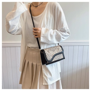 Close-up of a vintage embroidered crossbody bag with blue wave patterns on a model