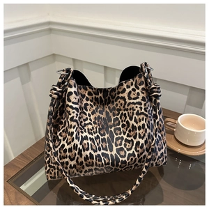 Detail of leopard print tote bag with knotted strap and silver hardware accents