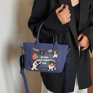 Blue denim tote bag with cartoon cat print and adjustable strap for casual wear