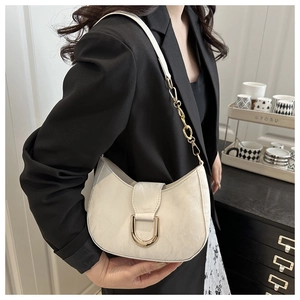 Close-up of vintage crackle leather shoulder bag with gold D-buckle and chain strap