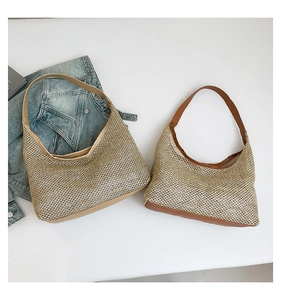 Detail of woven tote bags with leather straps in khaki and brown on a denim background