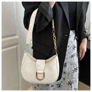 Detail of white vintage underarm bag with gold horseshoe clasp and textured leather finish