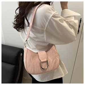 Pink pleated hobo bag with large gold D-ring buckle shown on shoulder