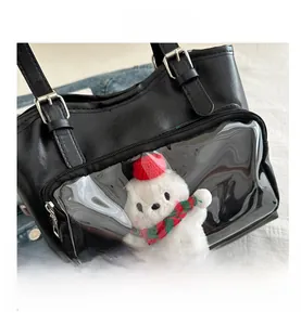 Detail of black tote bag with transparent PVC pocket and cute plush bear accessory