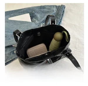 Interior view of black PU tote bag showing capacity with umbrella and wallet