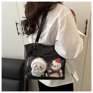 Close-up of black PU leather tote bag featuring transparent PVC window with plush charms