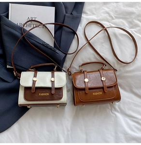 Detail view of vintage oil wax leather mini crossbody bags on navy blazer background