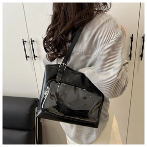 Detail of black PU leather tote bag featuring a transparent PVC pocket and adjustable strap