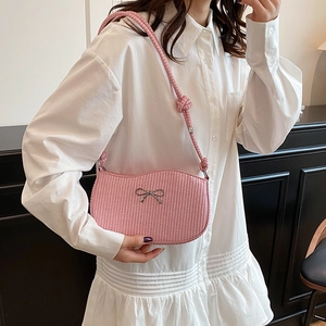 Pink woven crescent shoulder bag with silver bow accent and thick braided strap detail