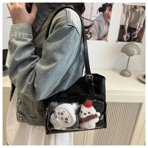 Detail of black PU tote bag with transparent PVC pocket showing cute plush charms