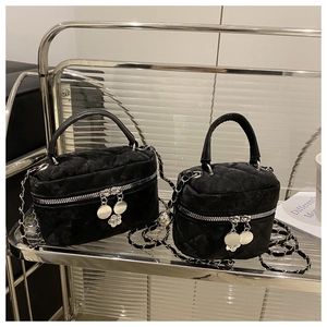 Détails du velours noir matelassé et des breloques fleurs argentées sur les sacs à chaîne