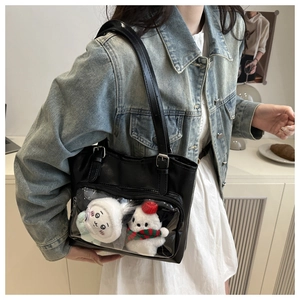 Detail of black ita bag with transparent PVC window and plush doll accessories for fans