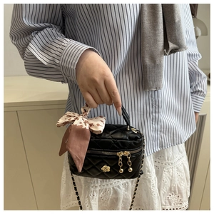 Détail du mini sac matelassé noir avec camélia doré et foulard à imprimé léopard