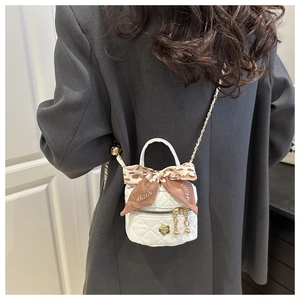 Détail du mini sac matelassé blanc avec ruban en soie léopard et bandoulière dorée
