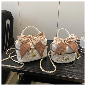 Close-up of white quilted mini bags with gold chains and leopard silk scarf detail