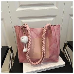 Detail of pink denim tote bag featuring woven handle, fashion print, and plush charm decor