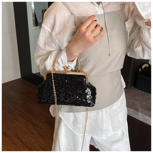 Detail of black sequin evening clutch with golden circular handle and metallic chain