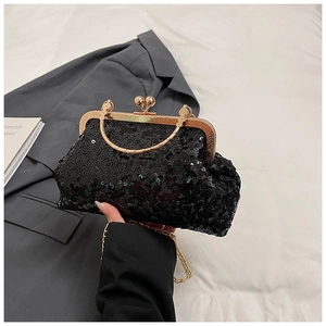 Detail of black sequined evening bag with champagne gold clasp and metal handle on grey suit