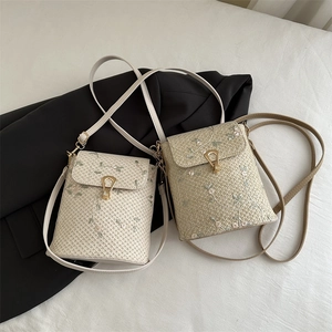 Mini sac seau en paille brodée avec boucle fer à cheval dorée et bandoulière