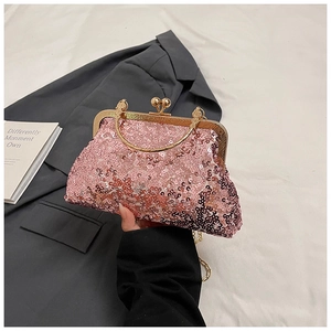Close-up of pink sequined evening clutch with golden metal frame and spherical clasp
