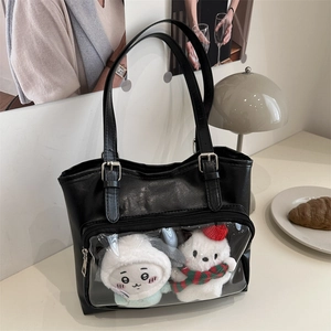 Black leather tote bag with transparent PVC window featuring cute plush dolls on a desk