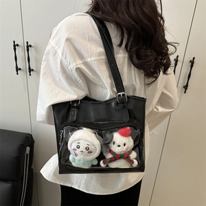 Minimalist black tote bag with clear display window showing plush toys on model