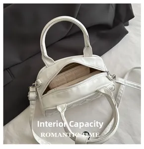 Internal capacity of white quilted Boston bag showing phone and quilted wallet details