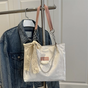 Large white canvas tote bag with pink leather straps and lace bow for spring fashion