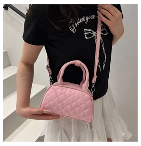 Detail of pink quilted Boston bag showing soft leather texture and silver metal hardware