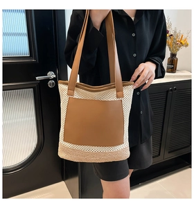 Detail of bohemian straw tote bag featuring contrast weave and brown leather pocket