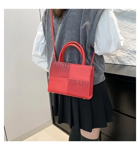 Grand sac à main rouge avec empiècements effet crocodile porté à l'épaule
