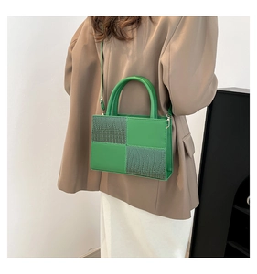 Détail du sac carré vert avec patchwork en crocodile et poignée supérieure fixe