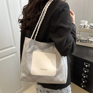 Gray quilted tote bag with white braided straps and FASHION pocket on a model