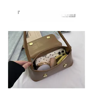 Vue intérieure montrant la grande capacité du sac baguette marron pour maquillage